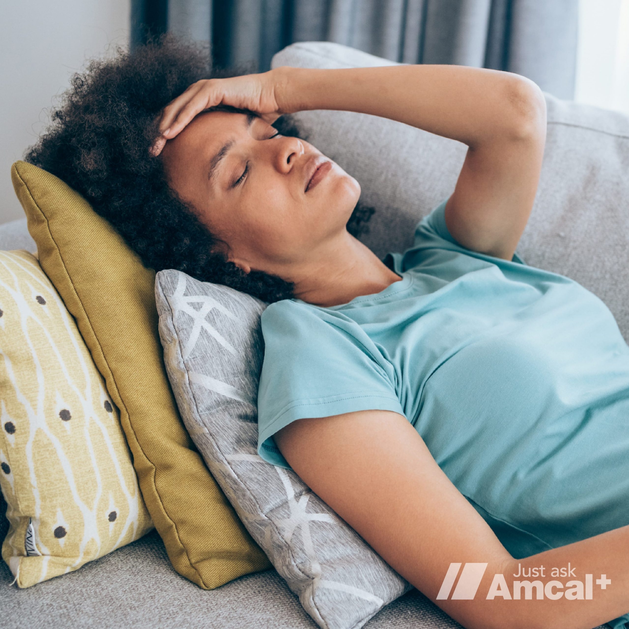 A person lying in a sofa having a headache