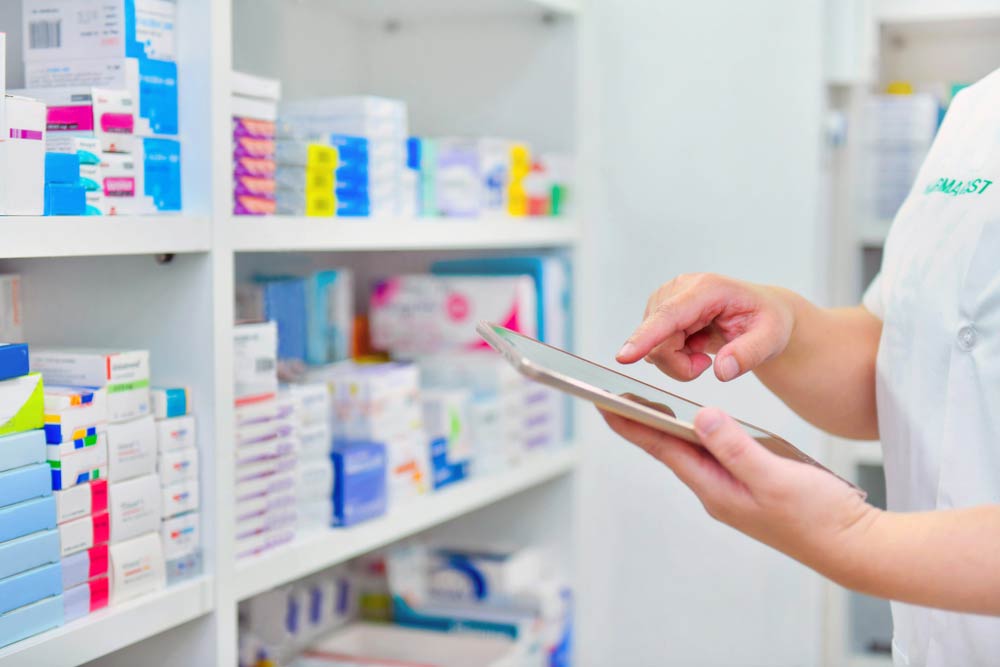 Pharmacist Holding A Tablet Device Filling Prescription